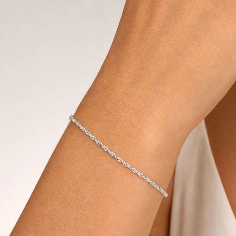 Pulseira feminina singapura torcida Zoe sendo usada no pulso em aço inoxidável antialérgico