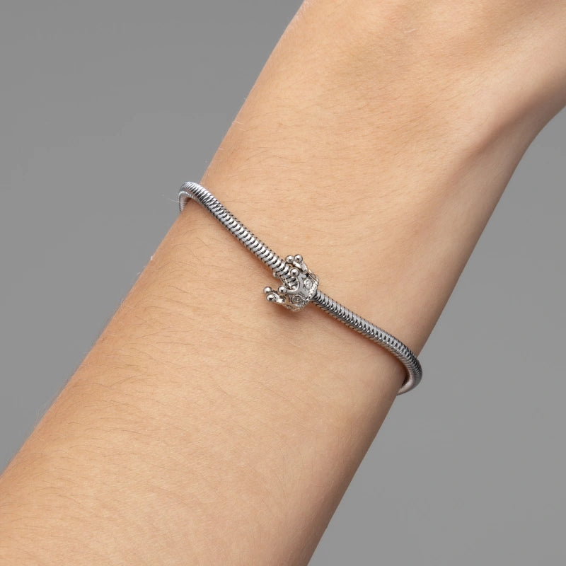 Berloque feminino Amélia coroa sendo usado em pulseira de aço inoxidável antialérgico