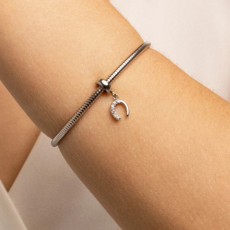 Berloque feminino Letícia ferradura sendo usado em pulseira de aço inoxidável antialérgico