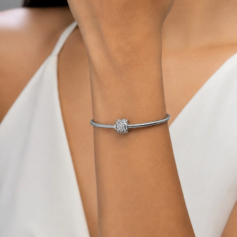 Berloque feminino Lorena separador floral sendo usado em pulseira de aço inoxidável antialérgico